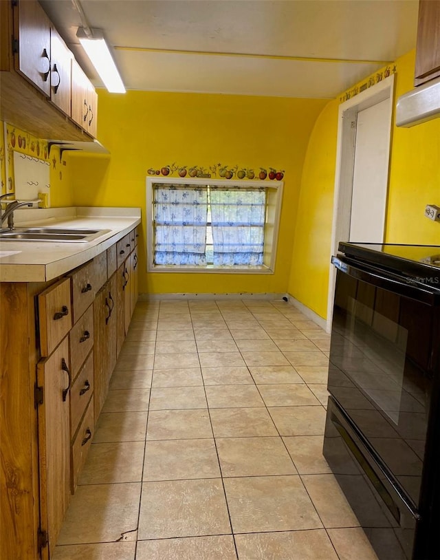 kitchen featuring black / electric stove, sink, and light tile patterned floors