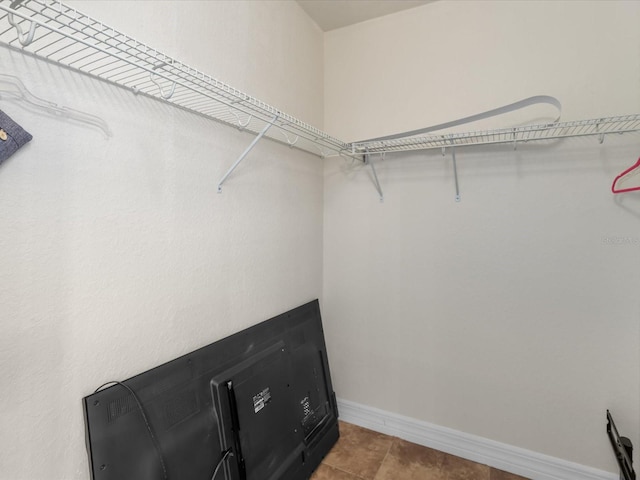 spacious closet with light tile floors