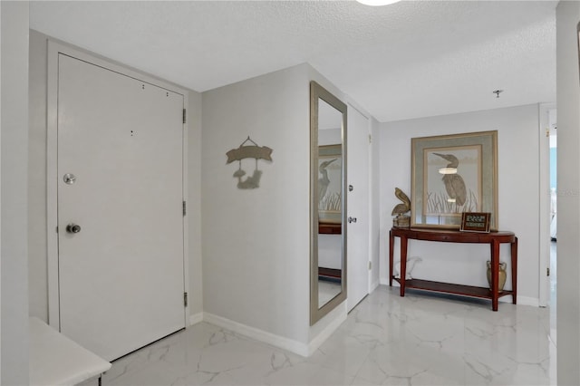 tiled foyer entrance featuring a textured ceiling