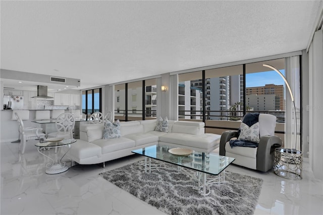 tiled living room with expansive windows and a textured ceiling