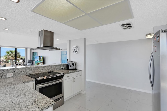 kitchen with island range hood, stainless steel appliances, light tile floors, light stone countertops, and white cabinetry