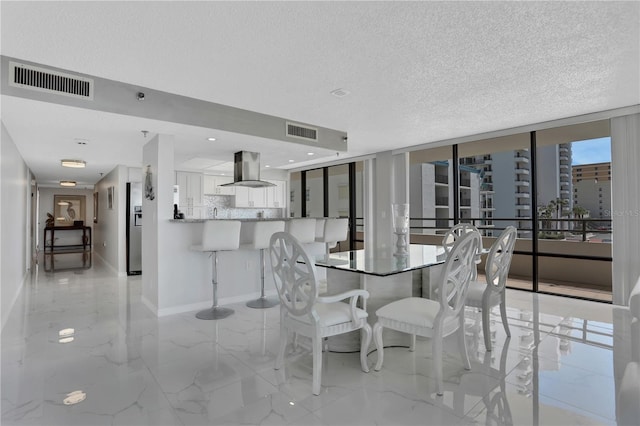 unfurnished dining area featuring light tile flooring, floor to ceiling windows, and a textured ceiling