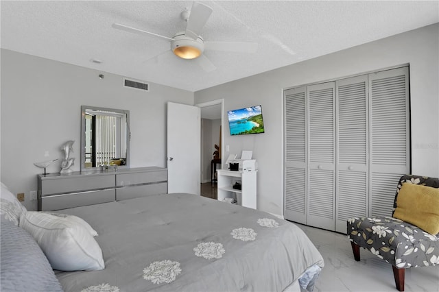 bedroom featuring a textured ceiling, a closet, and ceiling fan