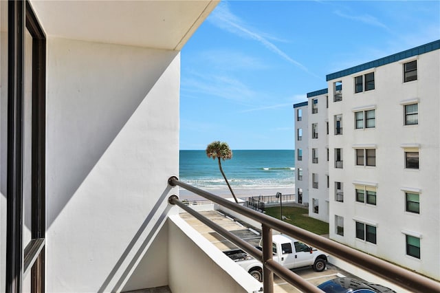 balcony with a water view and a beach view