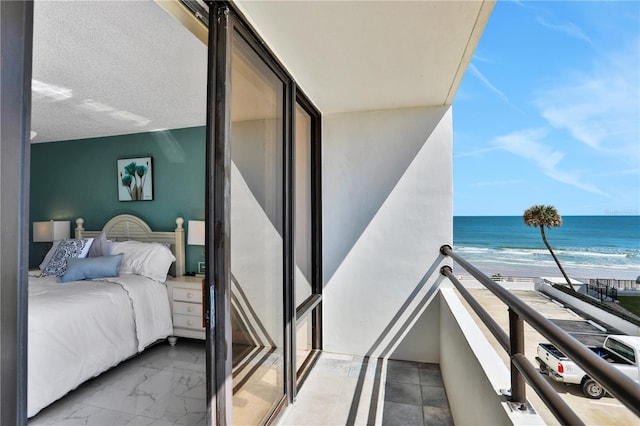 tiled bedroom with a textured ceiling, a beach view, and a water view