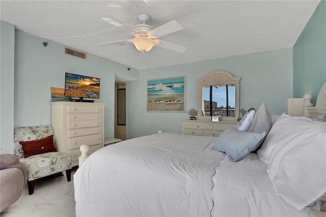 tiled bedroom featuring ceiling fan and a textured ceiling