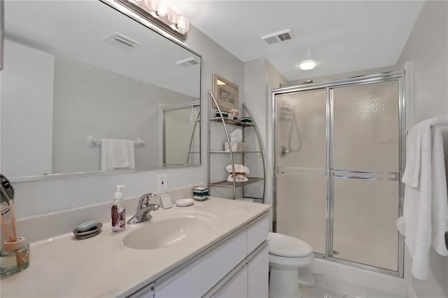 bathroom featuring an enclosed shower, vanity, tile flooring, and toilet