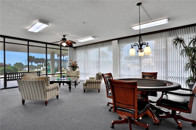 carpeted dining room featuring a textured ceiling and ceiling fan with notable chandelier