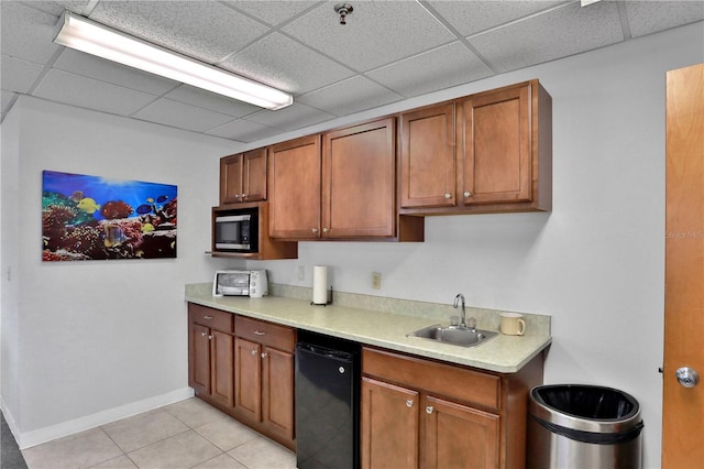 kitchen featuring sink, light tile floors, stainless steel microwave, dishwasher, and a paneled ceiling