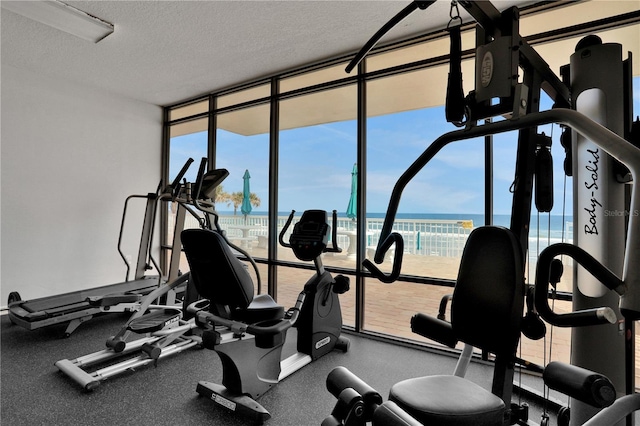 gym featuring a water view and a textured ceiling