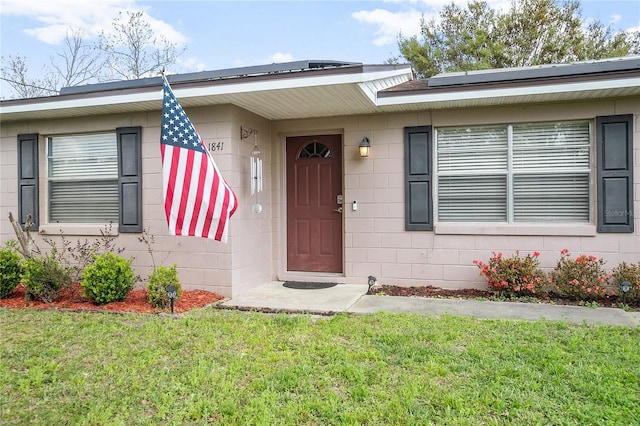 view of front of home with solar panels and a front yard