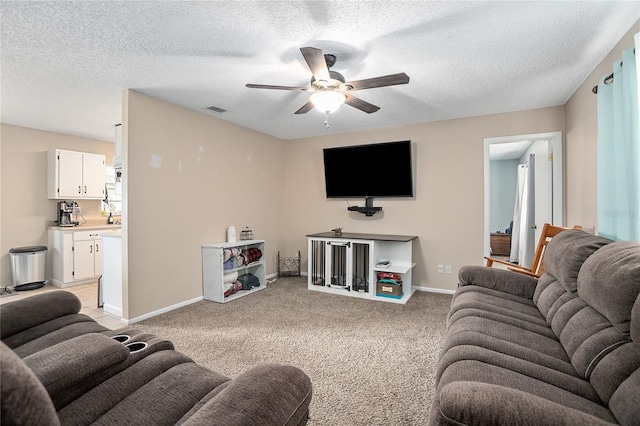 living room with light carpet, ceiling fan, and a textured ceiling