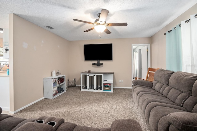 carpeted living room with plenty of natural light, ceiling fan, and a textured ceiling