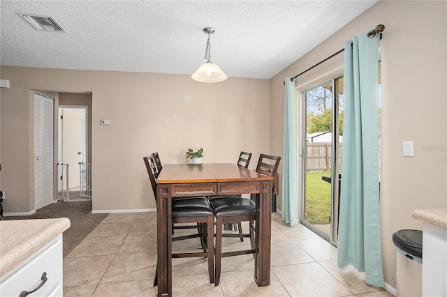 carpeted dining room with a textured ceiling