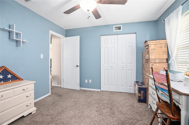 carpeted bedroom featuring a closet, ceiling fan, and a textured ceiling