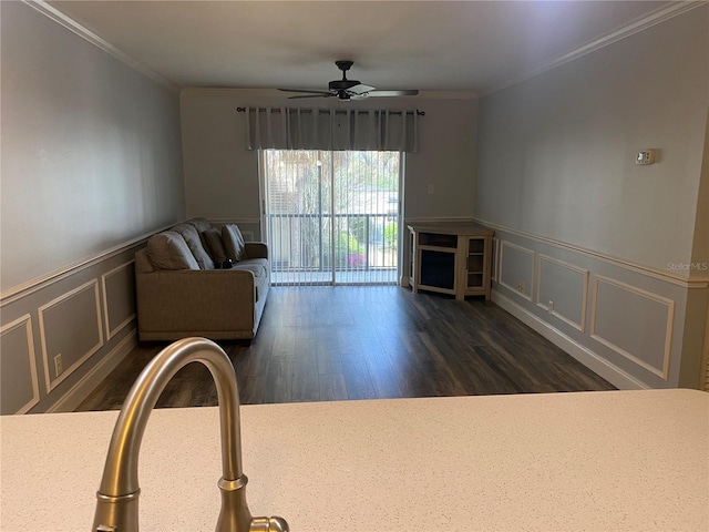 unfurnished living room featuring dark wood-type flooring, ornamental molding, and ceiling fan