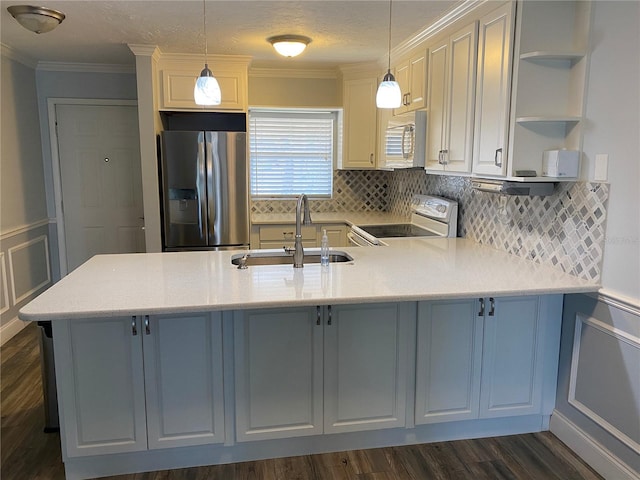 kitchen featuring white appliances, sink, hanging light fixtures, white cabinets, and tasteful backsplash