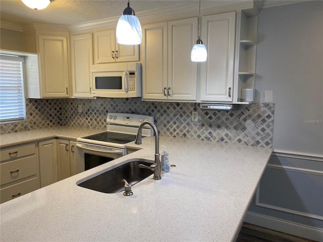 kitchen featuring white appliances, sink, cream cabinetry, backsplash, and decorative light fixtures