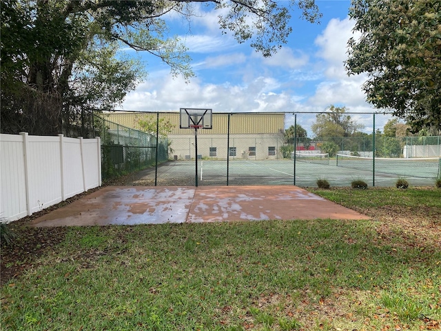 view of sport court with a yard