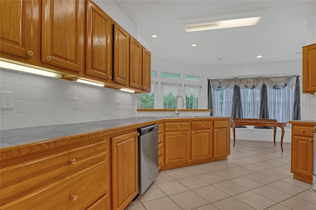 kitchen featuring light tile patterned flooring, tile countertops, sink, backsplash, and stainless steel dishwasher