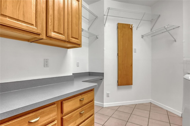 interior space featuring built in desk and light tile patterned flooring