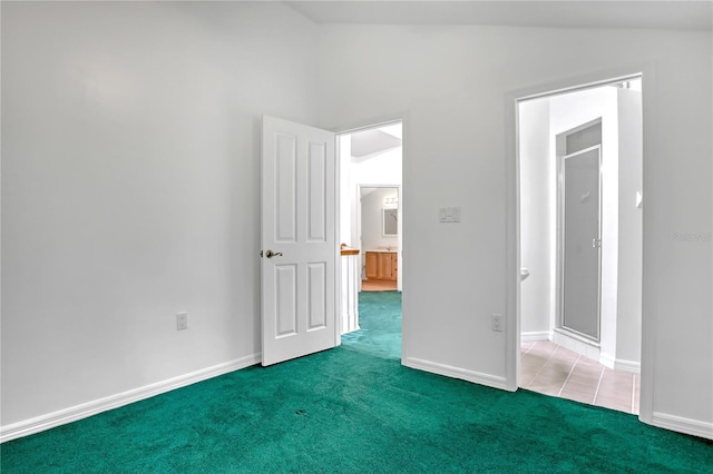 unfurnished bedroom with lofted ceiling and dark carpet