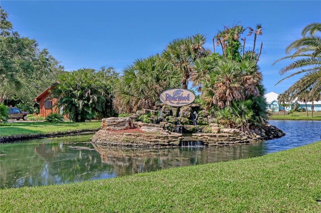 view of home's community with a water view and a yard