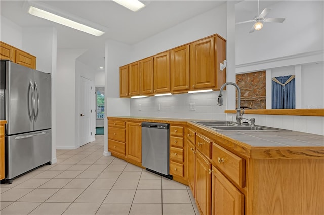 kitchen with light tile patterned flooring, sink, tasteful backsplash, vaulted ceiling, and appliances with stainless steel finishes