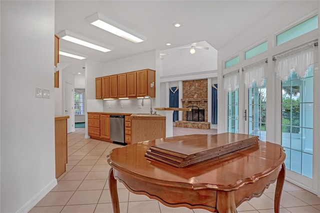 kitchen featuring light tile patterned flooring, lofted ceiling, sink, stainless steel dishwasher, and kitchen peninsula