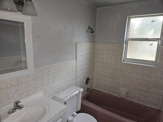 full bathroom with tile walls, tasteful backsplash, toilet, and tiled shower / bath combo