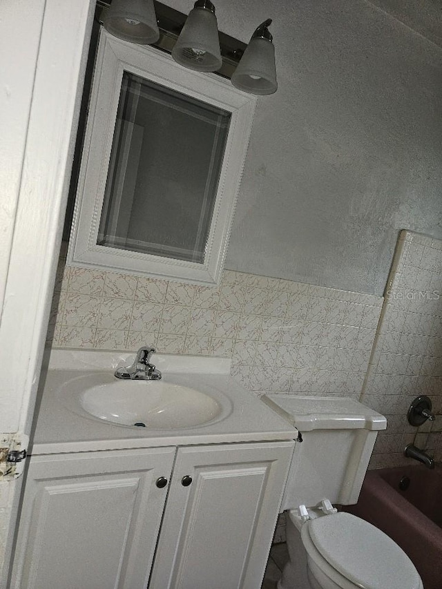 full bathroom featuring toilet, tiled shower / bath combo, and vanity