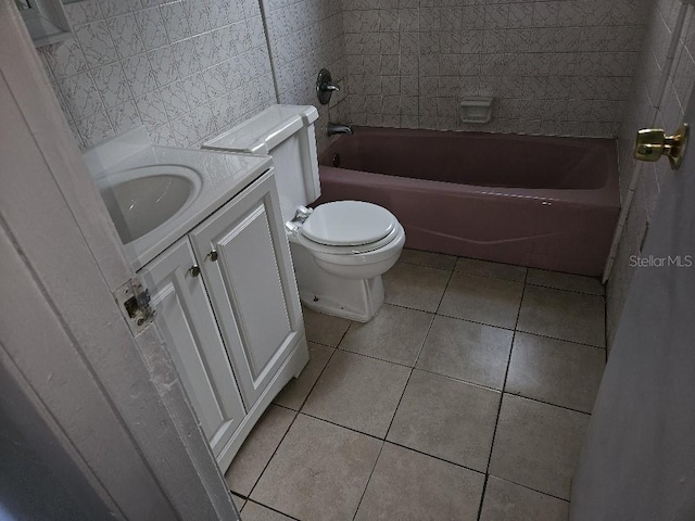 full bathroom featuring vanity, tile walls, tiled shower / bath, tile flooring, and toilet