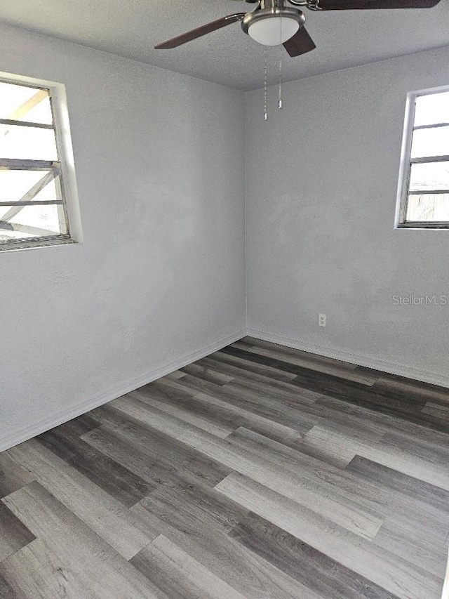 spare room featuring ceiling fan and dark wood-type flooring