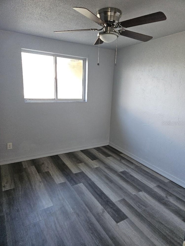 empty room featuring a textured ceiling, ceiling fan, dark hardwood / wood-style floors, and a wealth of natural light