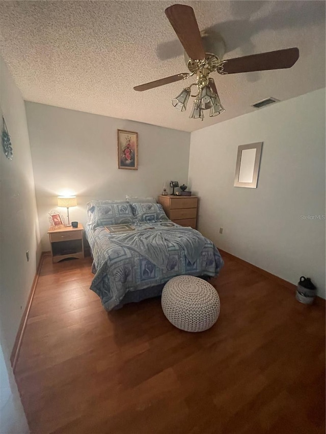 bedroom featuring wood-type flooring, ceiling fan, and a textured ceiling