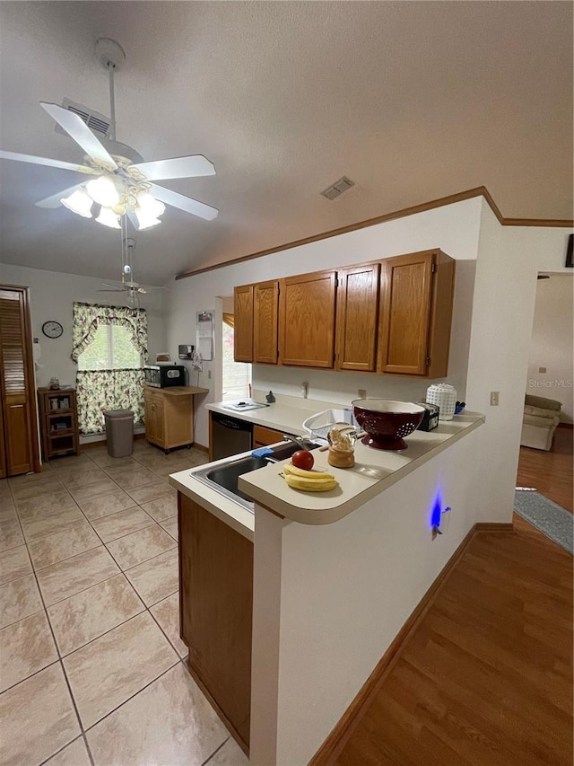 kitchen with light hardwood / wood-style flooring, dishwasher, ceiling fan, a textured ceiling, and kitchen peninsula