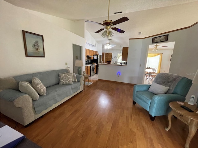 living room featuring ceiling fan, lofted ceiling, and wood-type flooring