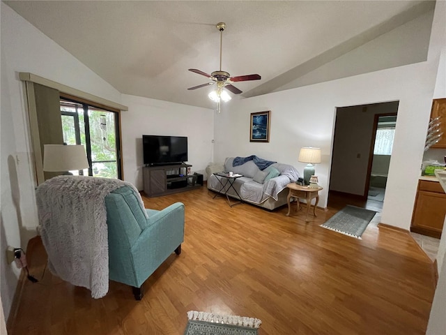 living room with ceiling fan, lofted ceiling, and light wood-type flooring