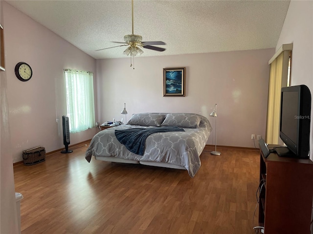 bedroom featuring lofted ceiling, ceiling fan, hardwood / wood-style flooring, and a textured ceiling