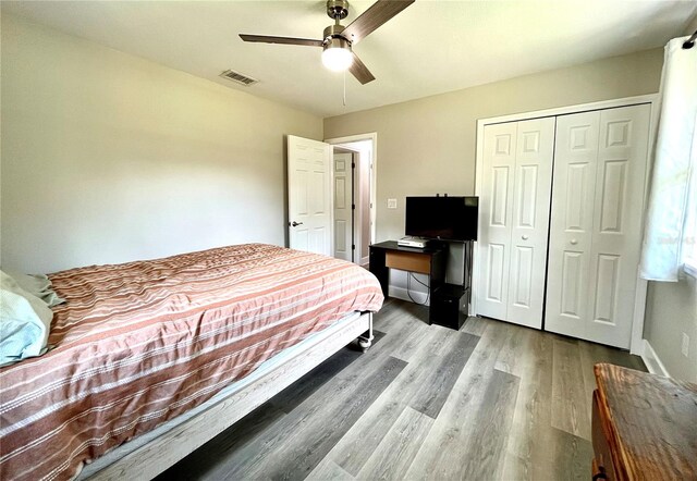 bedroom featuring hardwood / wood-style flooring, ceiling fan, and a closet