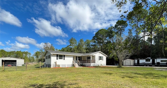 view of front facade featuring a storage unit, covered porch, and a front yard