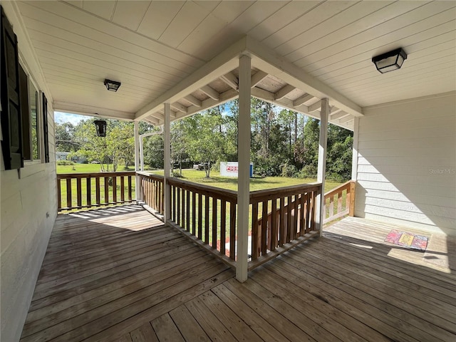 wooden deck featuring a lawn