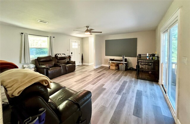 living room with ceiling fan and light hardwood / wood-style flooring