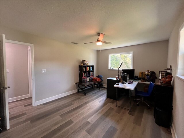 home office with ceiling fan, wood-type flooring, and a textured ceiling