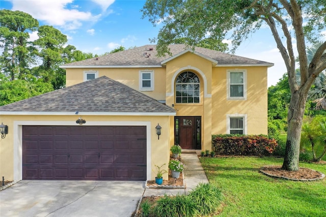 traditional home featuring a garage, concrete driveway, a front yard, and stucco siding