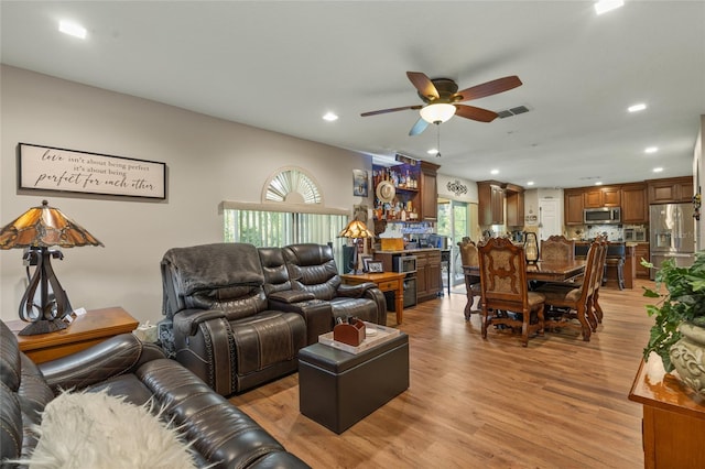 living room featuring ceiling fan and light wood-type flooring