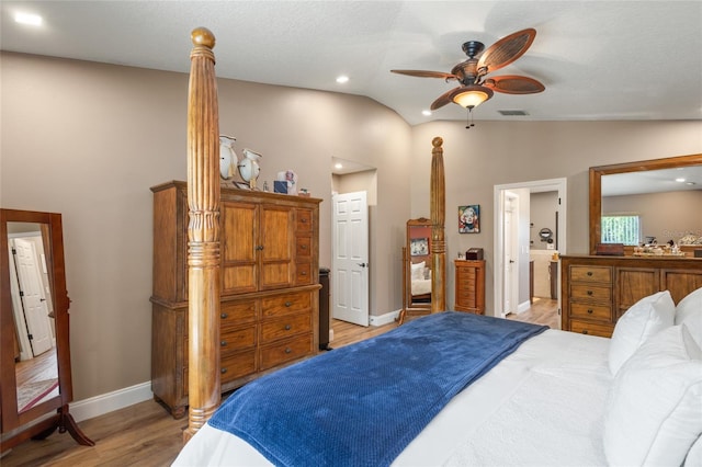 bedroom with ensuite bath, light hardwood / wood-style floors, ceiling fan, and vaulted ceiling