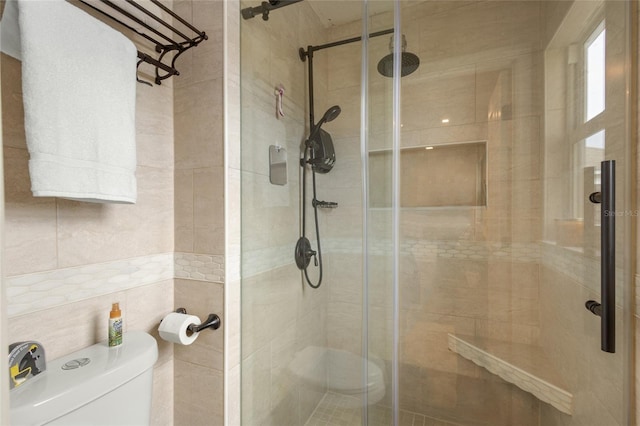 bathroom featuring tile walls, toilet, and an enclosed shower