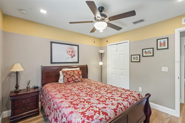 bedroom with ceiling fan, light hardwood / wood-style floors, and a closet