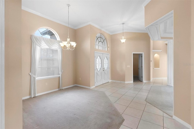 foyer featuring light tile patterned floors, an inviting chandelier, plenty of natural light, and ornamental molding